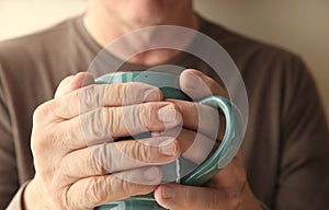 Hands of a man around coffee cupÂ Â 